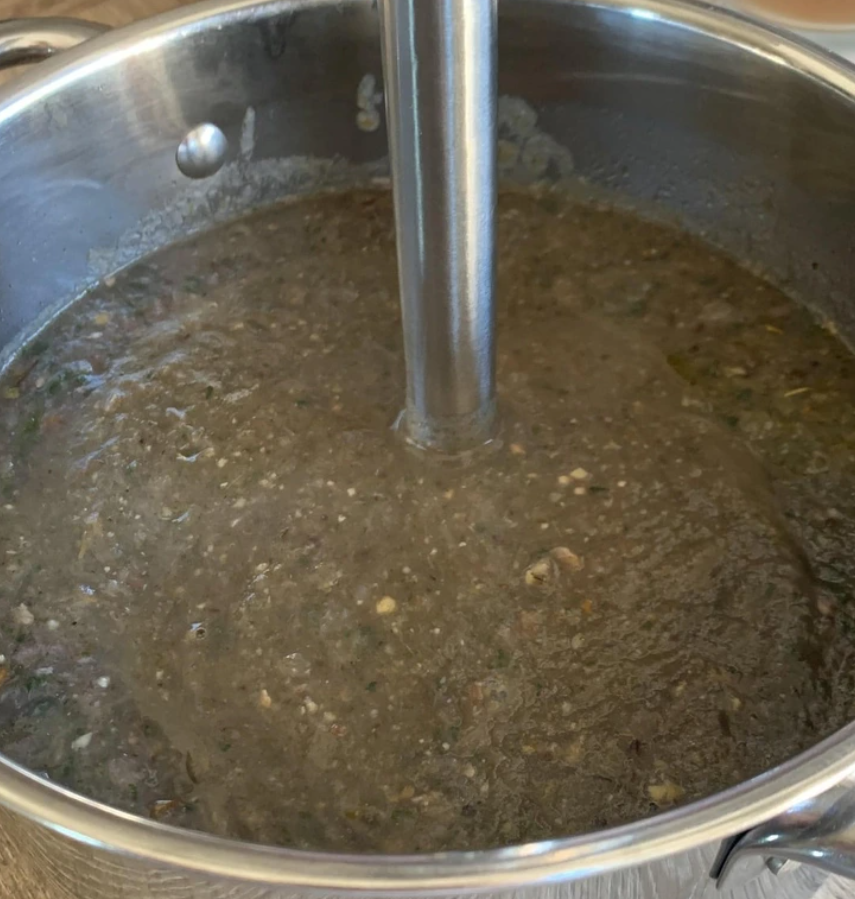 Ponorný mixér v hrnci s hnedou polievkou.