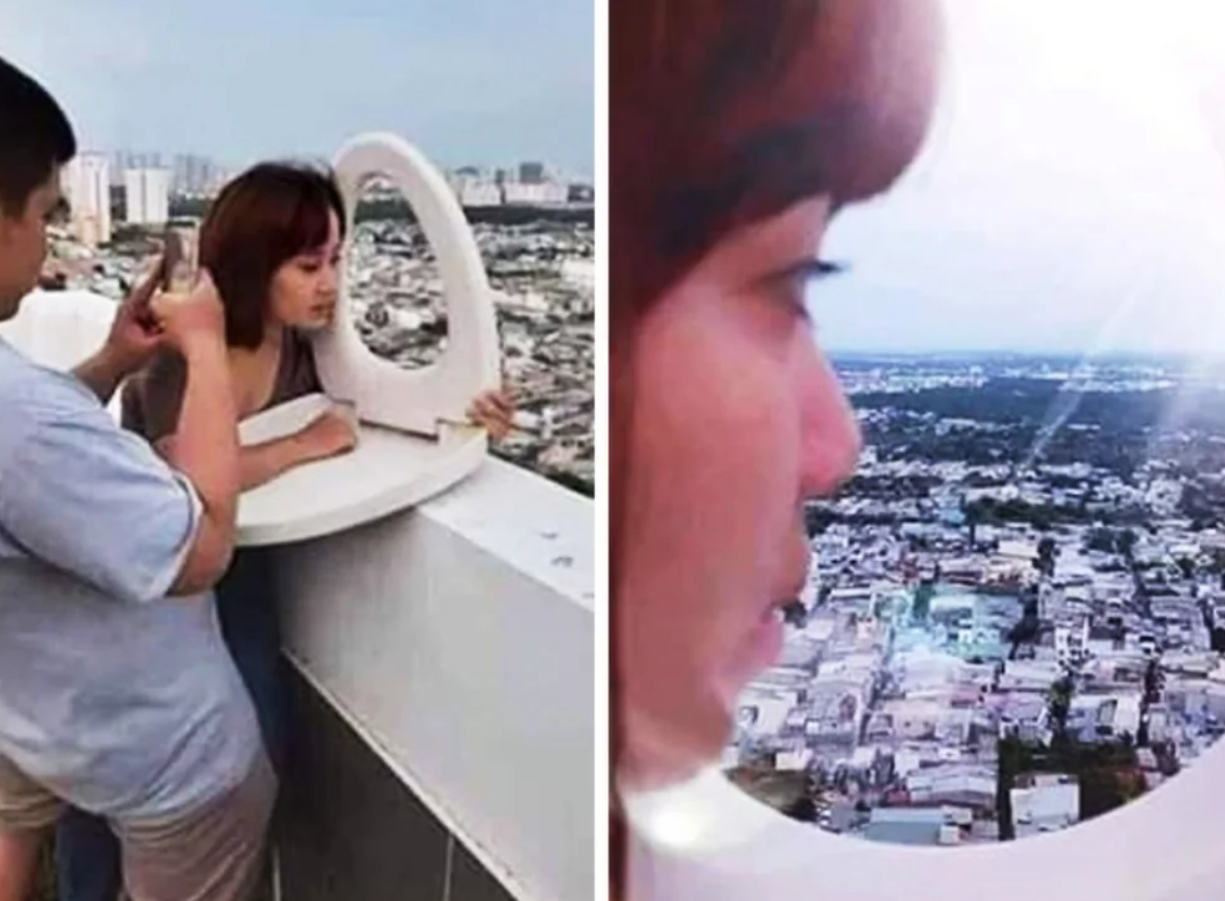 Osoba na streche pozerá cez záchodové sedadlo na panorámu mesta, zatiaľ čo ju niekto fotografuje.