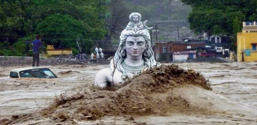 Povodeň pohltila sochu boha v Indii, auto aj chodci zápasia s vyčíňaním vody.