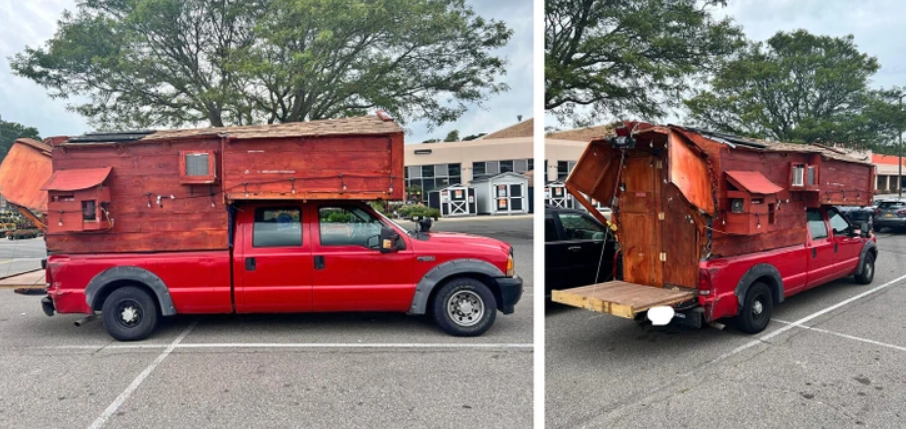 Červené nákladné auto s prepracovanou drevenou konštrukciou ako obytným prívesom, zaparkované na parkovisku.