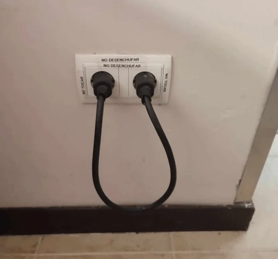 Dvojitá zásuvka s prepojenými káblami, označená španielskými nápismi, ktorá vytvára uzavretý okruh.