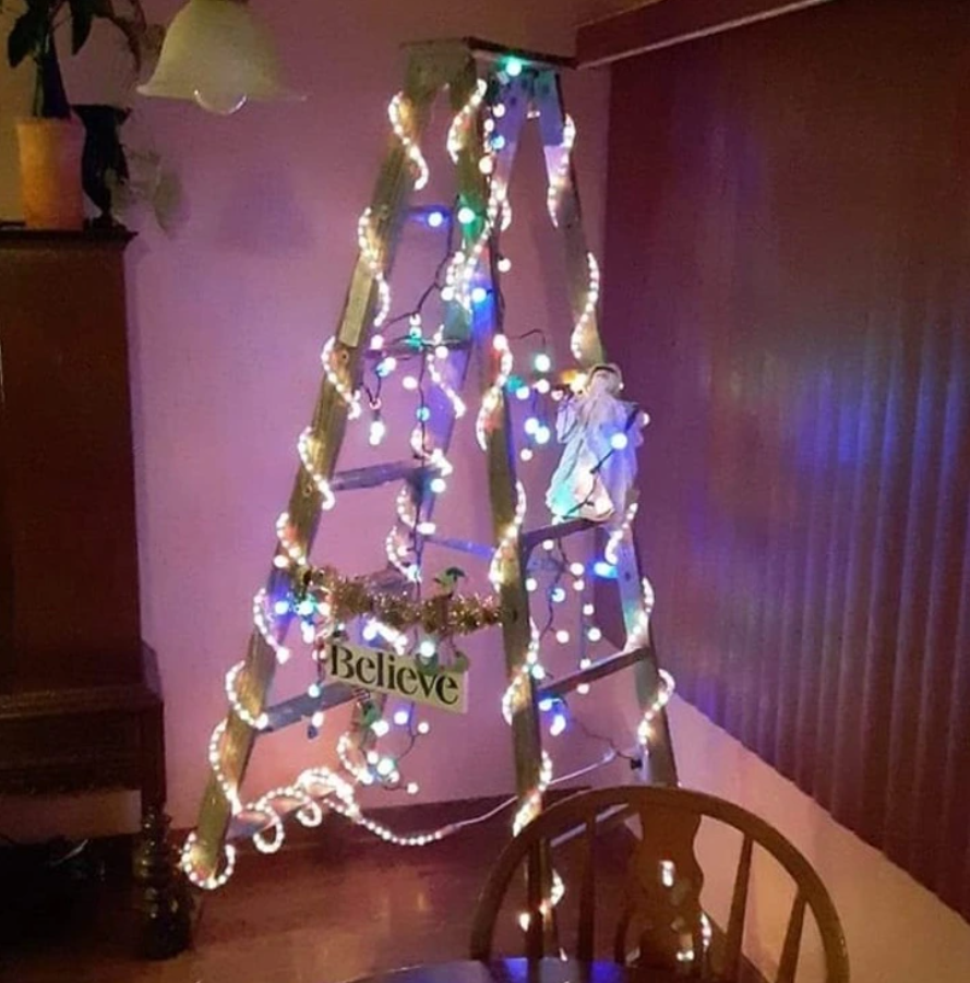 Dekoratívny rebrík s vianočnými svetlami v rohu miestnosti.