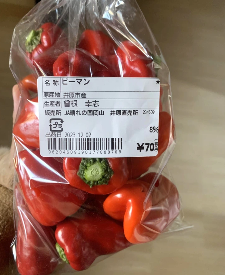 Balíček červených paprík s cenovkou a japonským popisom. Dátum distribúcie 2. decembra 2023.