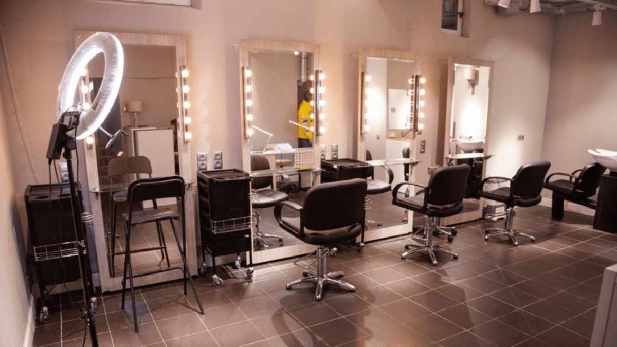 Moderný kadernícky salón so zrkadlami, osvetlením a ergonomickými stoličkami pripravený na zákazníkov.