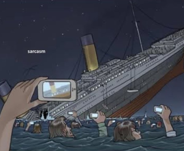 Ľudia vo vode si fotia potápajúcu loď v noci.