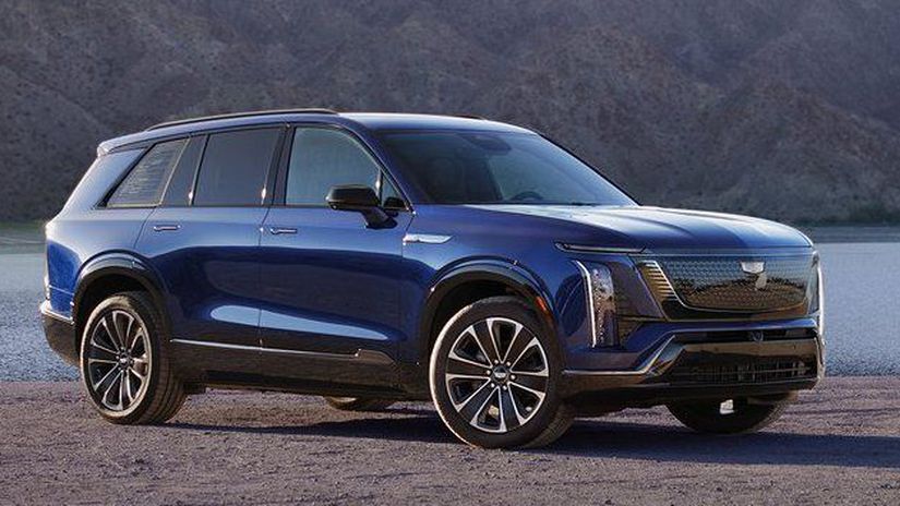 Modrý SUV zaparkovaný pri jazere v horskej krajine, ideálny pre dobrodružstvá v prírode.