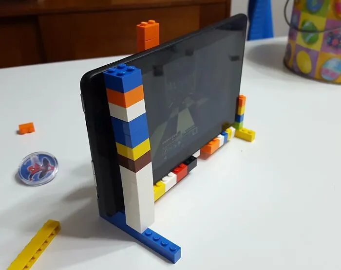 Tablet na stole s podperou z farebných LEGO kociek.
