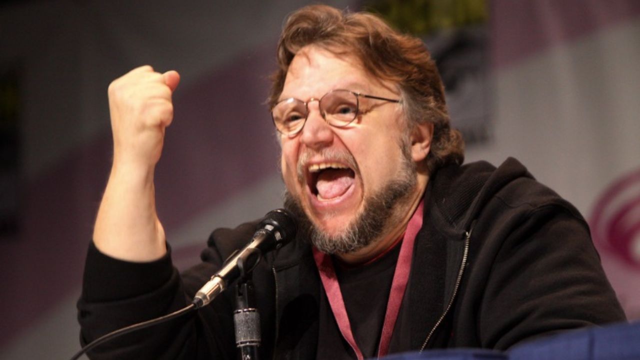 Osoba gestikulujúca za mikrofónom na podujatí.