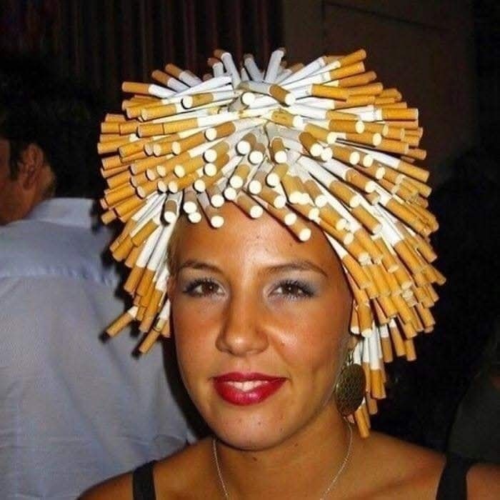 Žena s originálnym účesom z cigariet, kreativita na večierku.