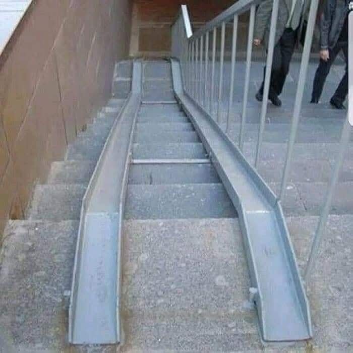Rampy na schodoch pre kočíky alebo invalidné vozíky v meste s prítomnosťou dvoch schádzajúcich osôb.