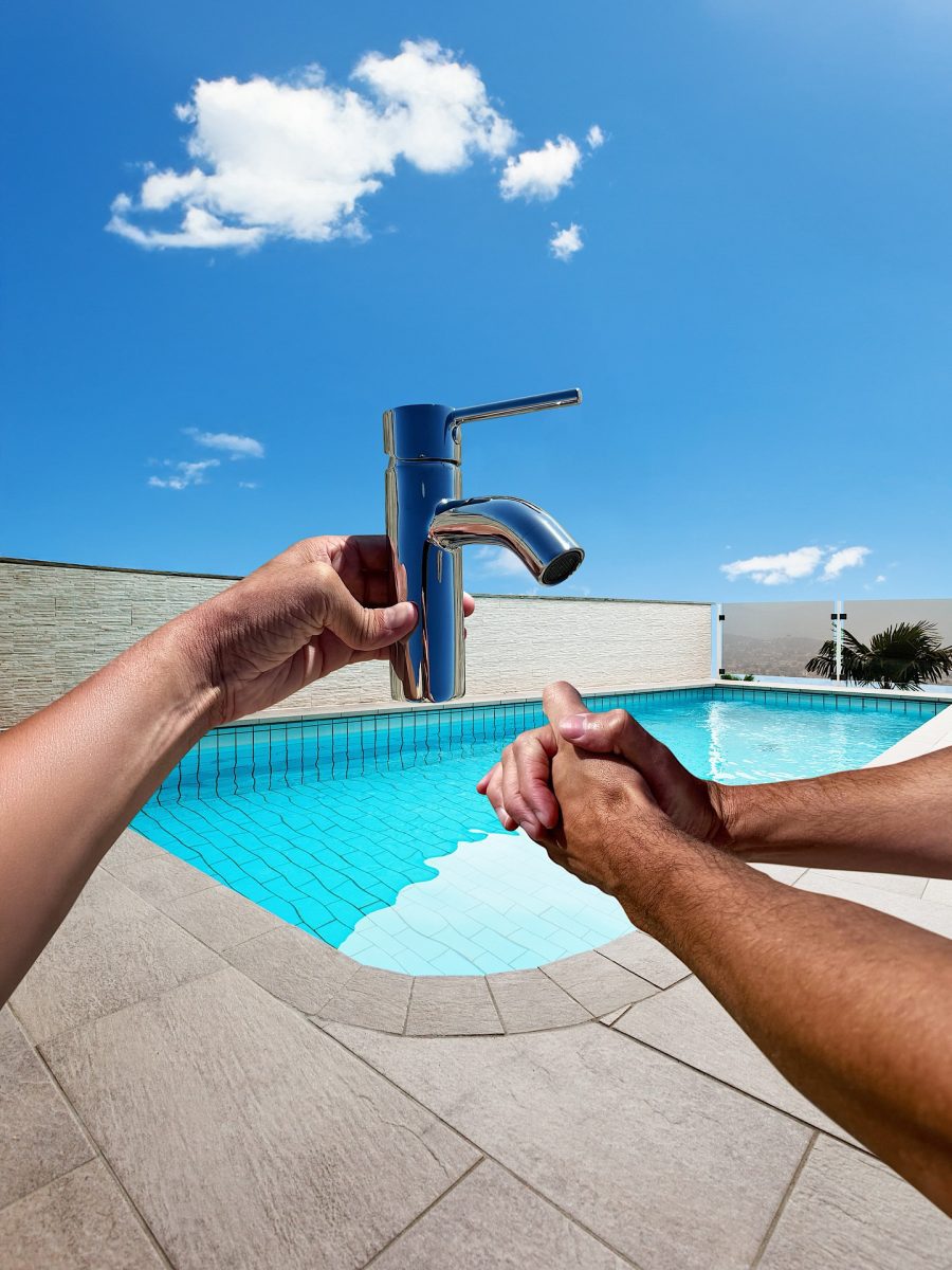 Osoba drží modernú batériu pri bazéne pod modrou oblohou, čo symbolizuje inštalatérske práce a dizajn.