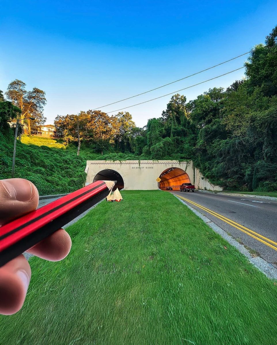 Ručne kreslená ilúzia ceruzkou pri vstupe do tunela v zalesnenej krajine.