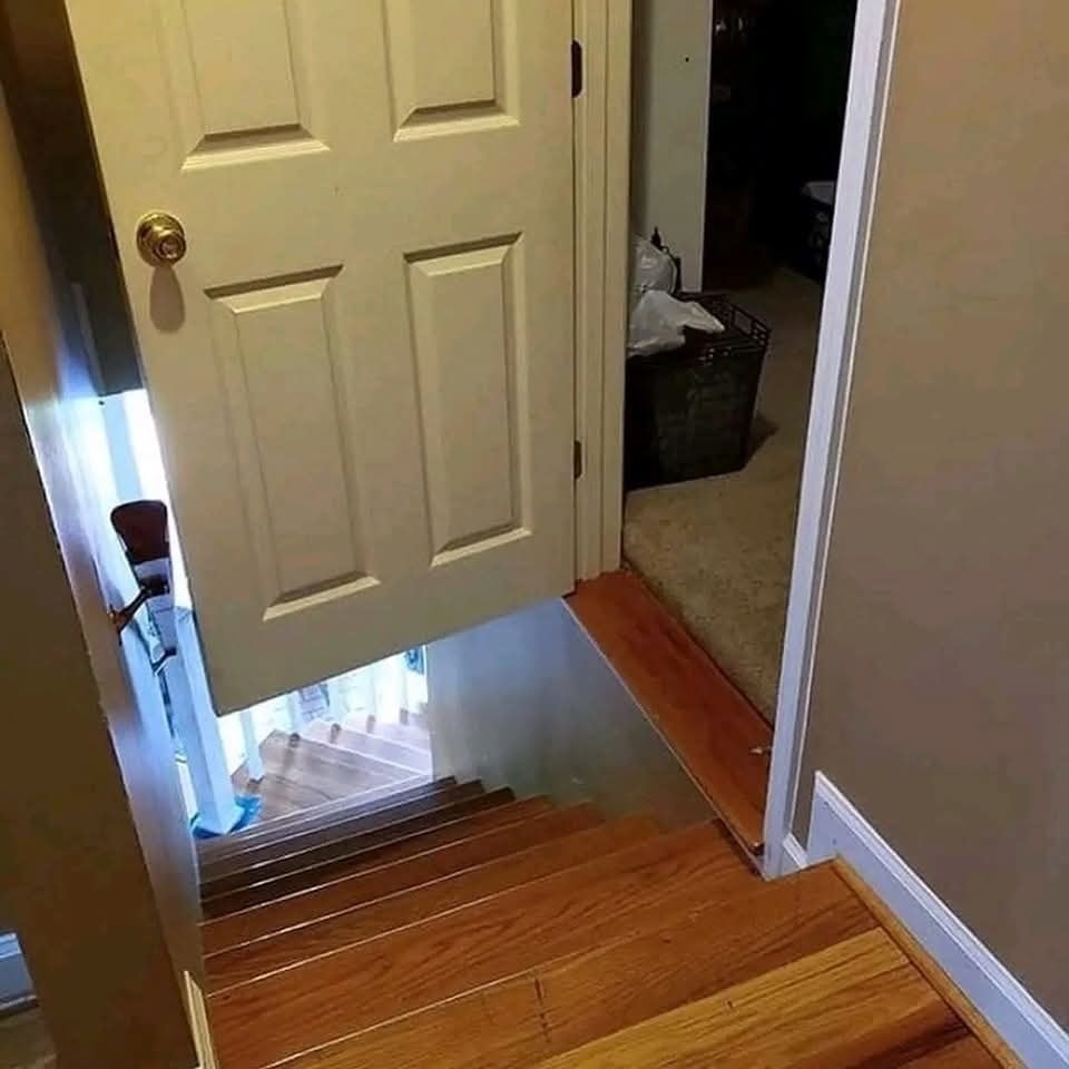 Dvere vedú priamo na schody bez podlahy, nezvyčajná architektonická chyba.