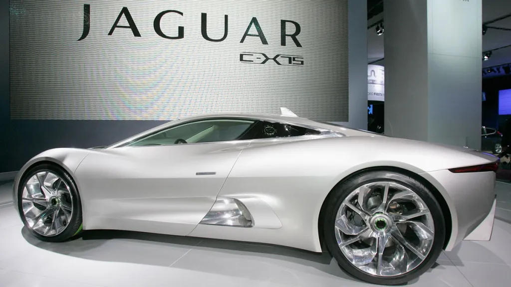 Strieborné auto Jaguar C-X75 vystavené v autosalóne, pohľad z bočnej strany. Futuristický dizajn a moderné línie.