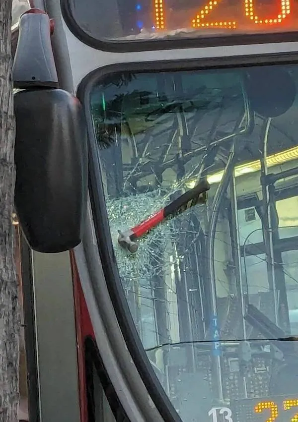 Kladivo uviaznuté vo vetre autobusu s číslom 120, rozbité sklo, neobvyklá dopravná situácia.