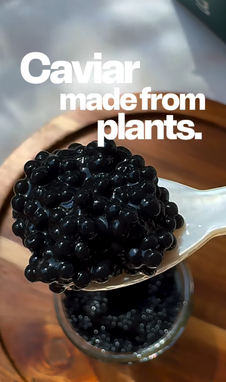 Vegánsky kaviár z rastlín na lyžičke nad pohárom, udržateľná alternatíva k tradičnému kaviáru.