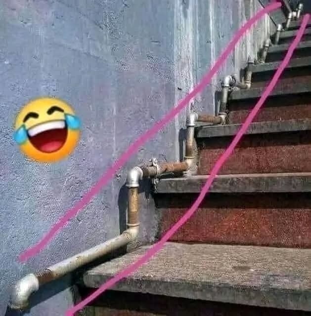 Schody s neobvyklým zábradlím z rúrok a kreslenou ružovou čiarou ukazujúci chybný dizajn, s emoji so smiechom.