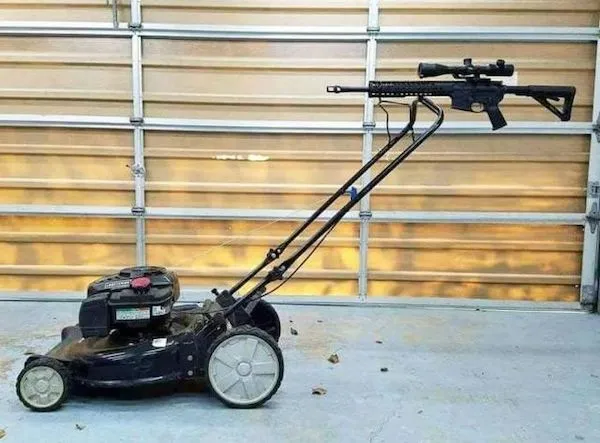 Neobvyklá kosačka s pripevnenou replikou pušky v garáži. Kreatívny dizajn alebo recesia?