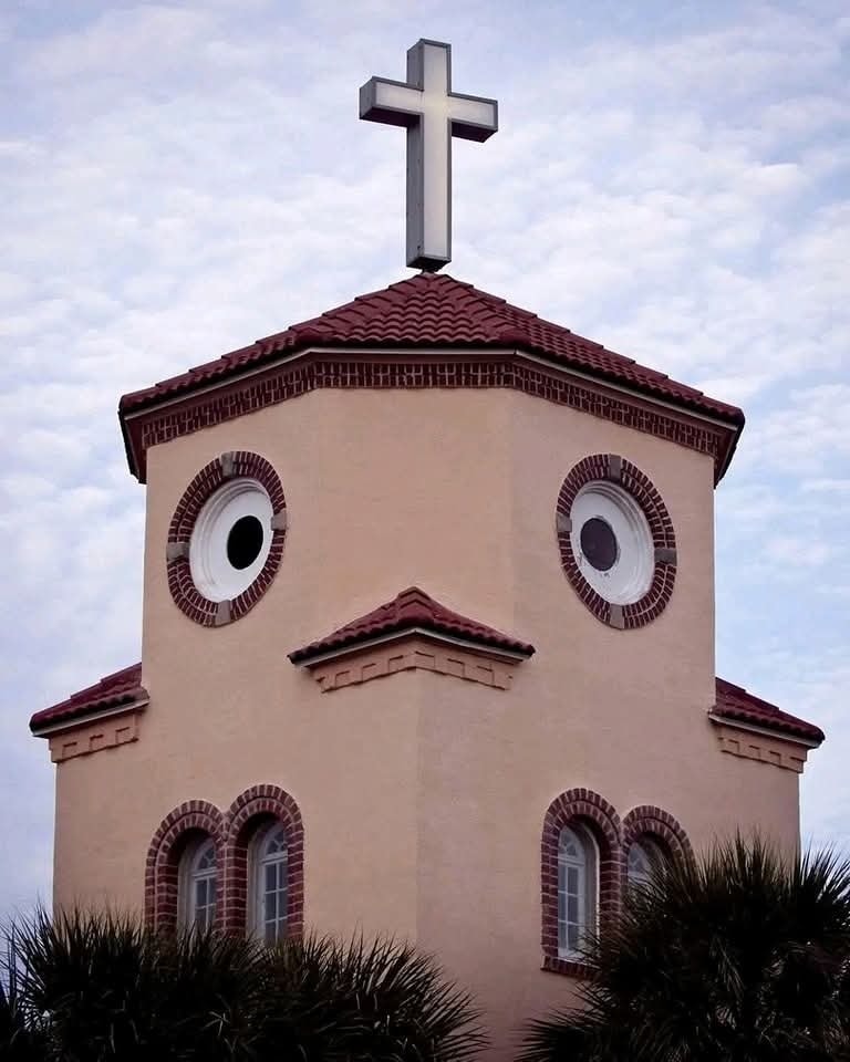 Budova pripomínajúca vtáka s krížom na streche, pripomína tvár s oknami ako oči.