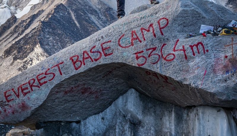 a man standing on top of a large rock