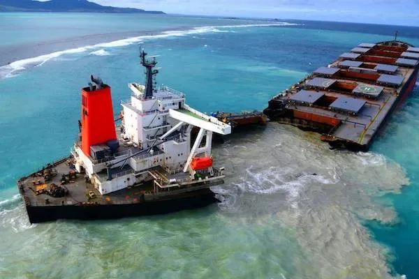 Nehoda lode rozlomenej v mori, kontaminácia okolitej vody pri pobreží, pohľad zhora, modré pozadie oceánu.