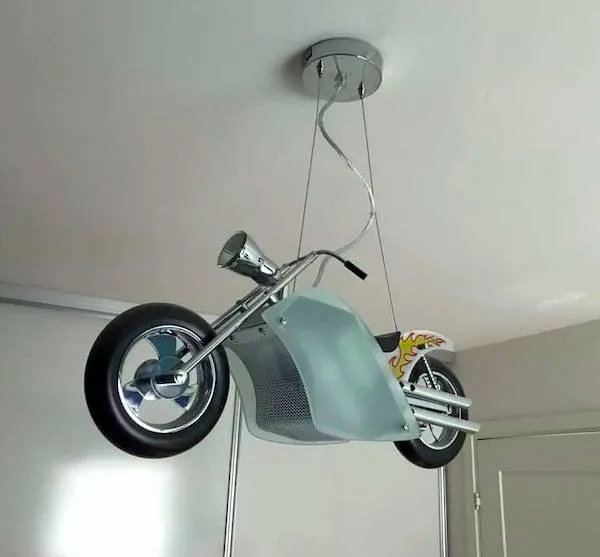 Motocykel na strope ako originálna lampa v izbe pre nadšencov motoriek.