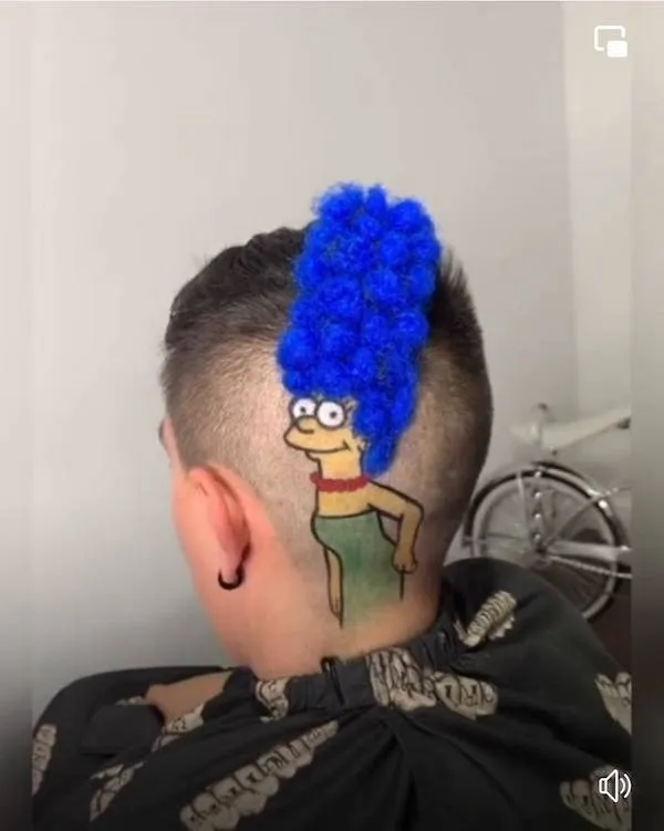 Osoba s účesom Marge Simpson s modrými vlasmi a tetovaním na hlave v originálnej kombinácii kresby a štýlu.