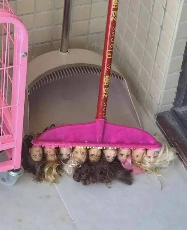 Metla s hlavami bábik namiesto štetín, originálna dekorácia na čistenie podlahy v miestnosti.