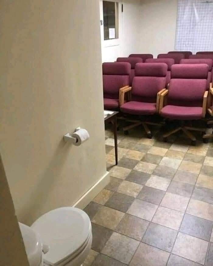 Kombinovaná miestnosť s toaletou a radom sedadiel v neobvyklej dispozícii, búrajúca bežné predstavy o súkromí.