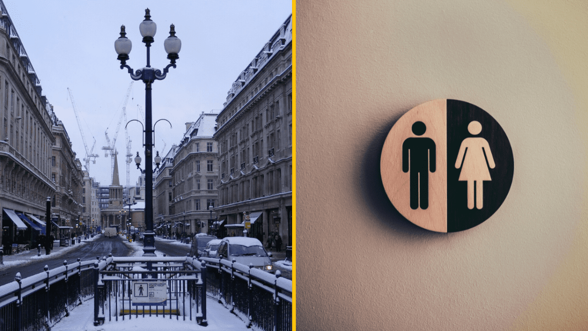 Zasnežená mestská ulica s lampami a značkou pre toalety na bielej stene.