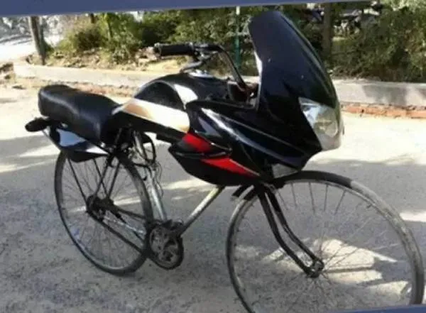 Retro bicykel s neobvyklou aerodynamickou kapotou zaparkovaný pri ceste, pripravený na jazdu.