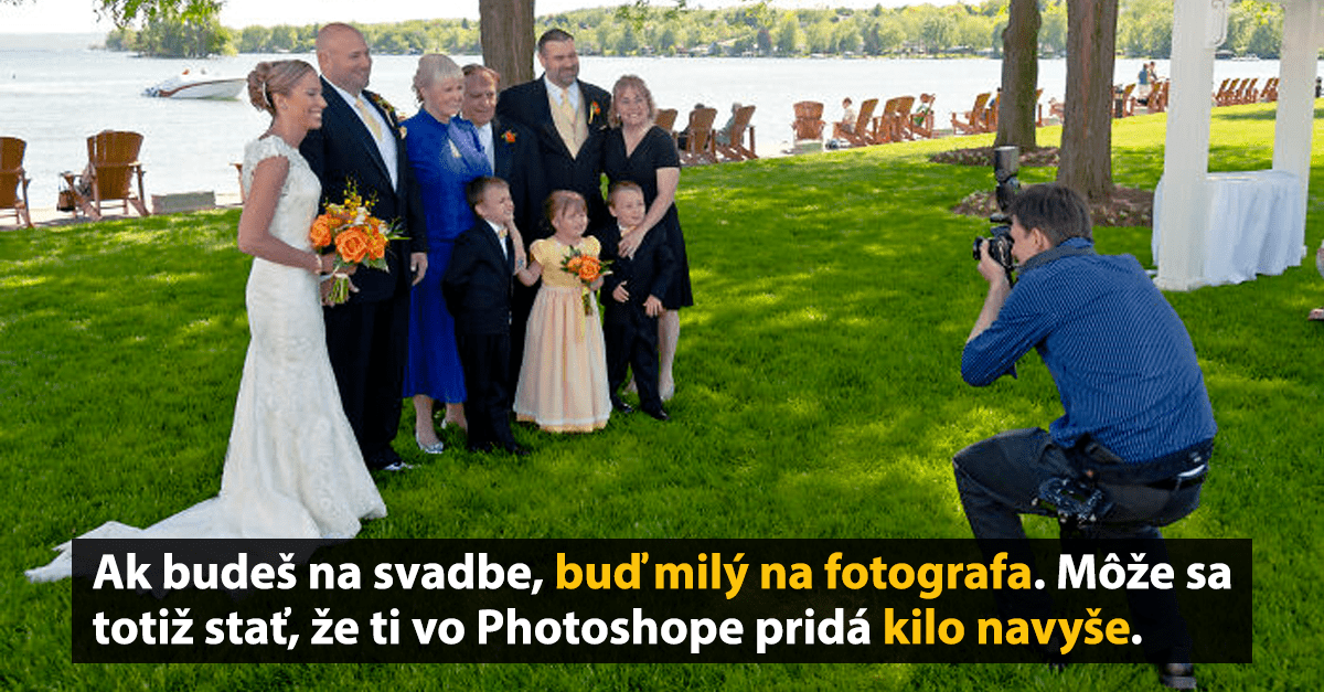 Svadobná fotografia s fotografom a skupinkou hostí na trávniku pri vode.