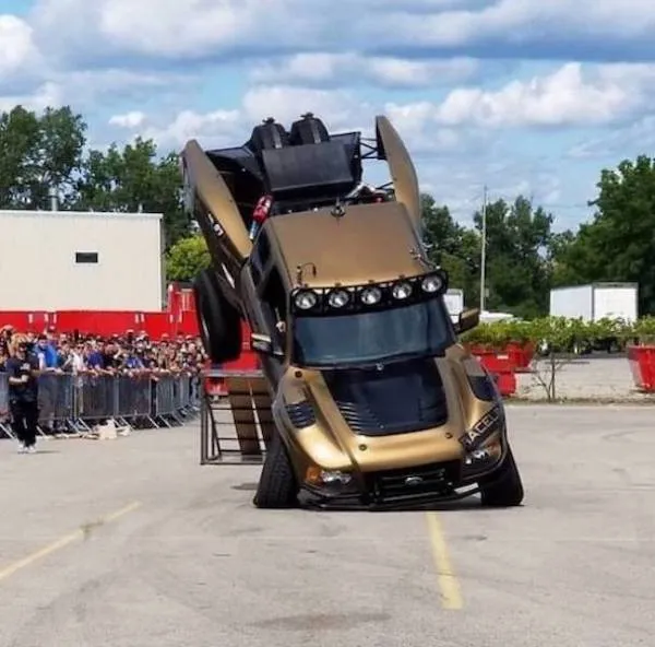 Monster truck predvádza neuveriteľný kaskadérsky kúsok na rampách počas motoristickej show na otvorenom priestranstve.