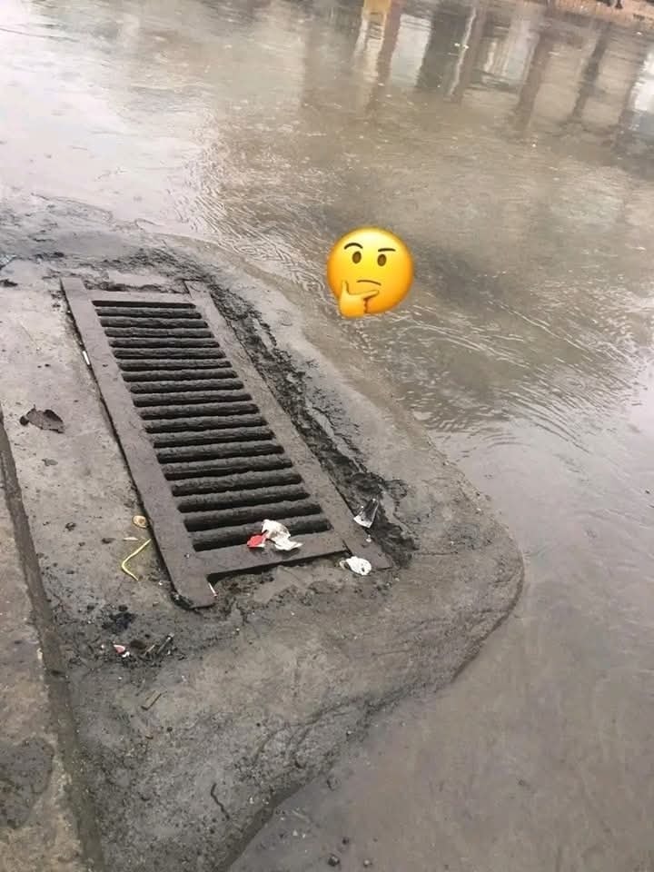 Zápcha kanálu počas dažďa, voda sa hromadí a emoji rozmýšľa, prečo sa neodteká.