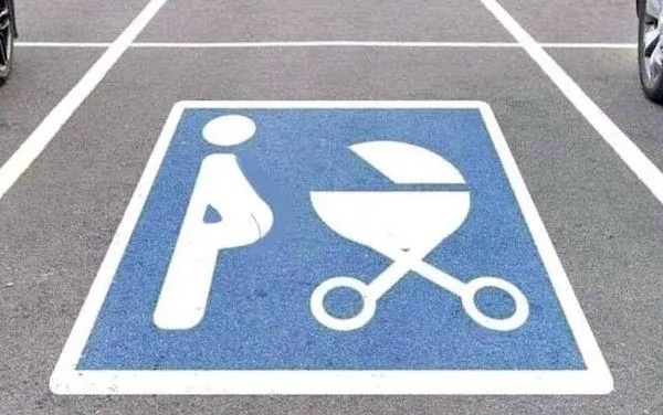 Vyhradené parkovacie miesto pre tehotné ženy a rodičov s kočíkmi, označené piktogramom na asfalte.