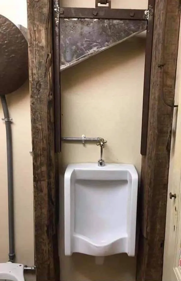 Urimio umývadlo s nevšedným dreveným rámom a starožitným výzorom na pozadí steny.