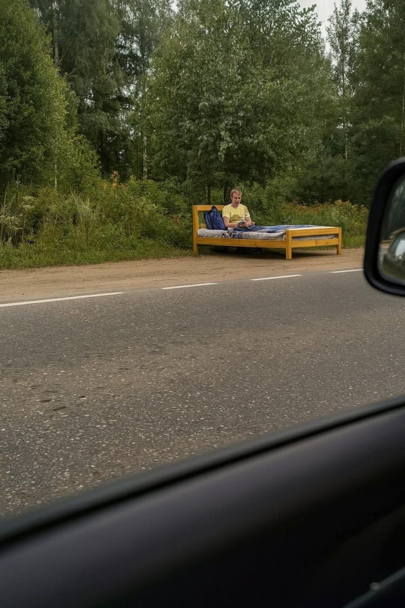 Osoba na posteli pri ceste v lese, sediaca s mobilom na drevenom ráme.