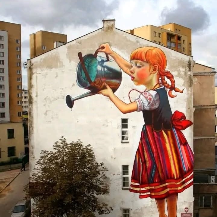 Maľba dievčaťa s kanvicou na dome, vytvára ilúziu zalievania stromu, mestské umenie.