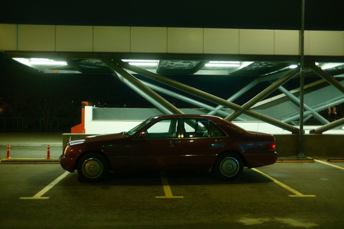 A red car is parked in a parking lot