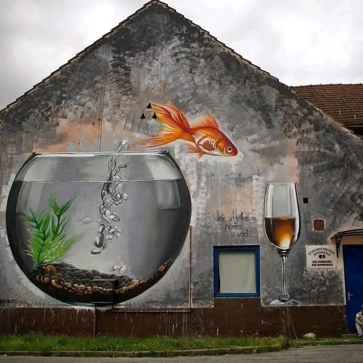 Nástenná maľba s akváriom, zlatou rybkou a pohárom na víno na starej omietke rustikálneho domu.
