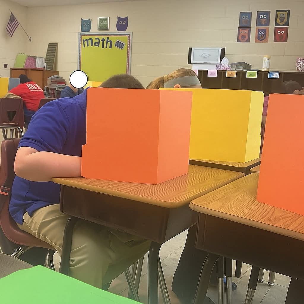 Školská trieda s farebnými zábranami na laviciach počas testu matematiky.