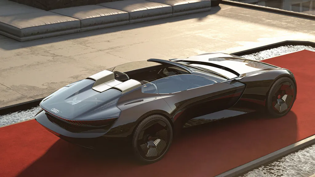 Futuristické Audi koncept auto na červenom koberci, otvorená strecha, moderný dizajn.