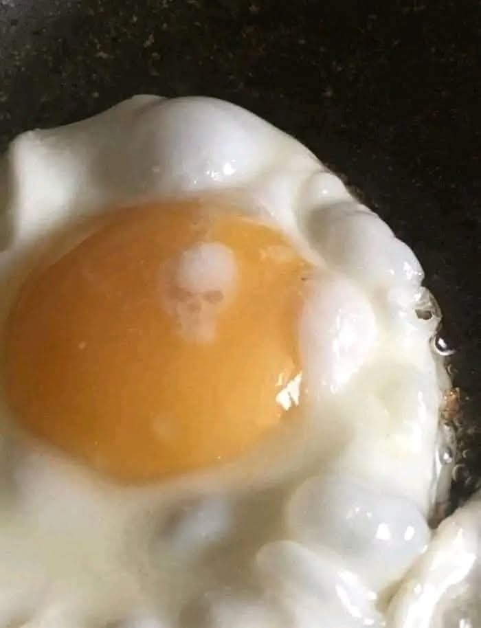 Vajíčko na panvici, žĺtok obklopený bielou, pripravené na raňajky.