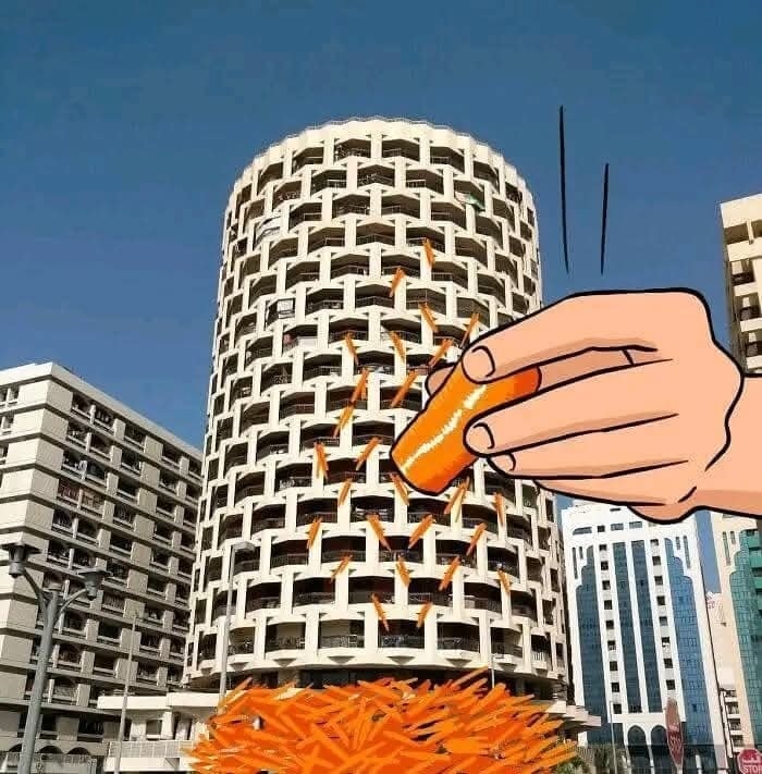 Budova vyzerajúca ako strúhaná mrkva s rukou držiacou strúhadlo na pozadí mestských stavieb.