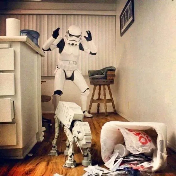 Stormtrooper vyrazí zmetený papag a plyšového AT-AT v kuchyni. Upadnutý kôš a chaos na podlahe.