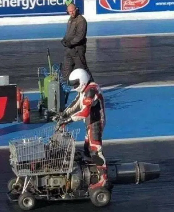 Pretekár na okruhu v netradičnom vozidle s prúdovým motorom a nákupným vozíkom.