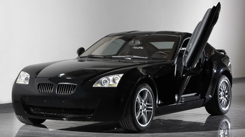 Športové čierne auto s vyklápacími dverami na výstavnej ploche, moderný dizajn a elegantné línie.