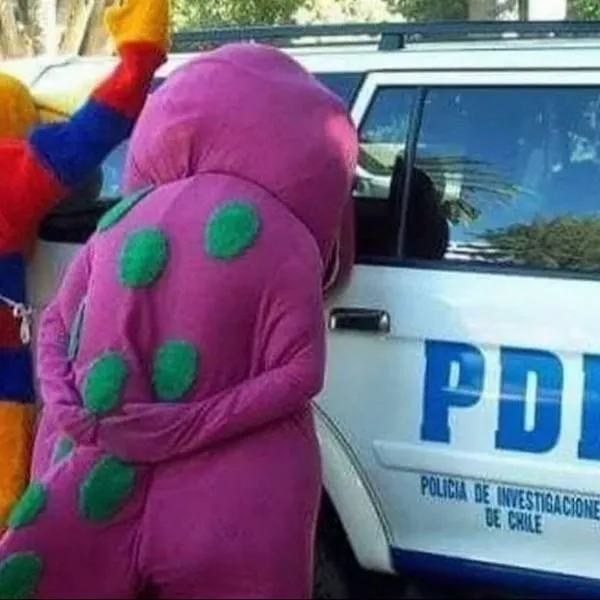 Kostýmy dinosaurov a vtákov pri policajnom aute v čílskom parku. Scéna vyvoláva úsmev a zvedavosť.