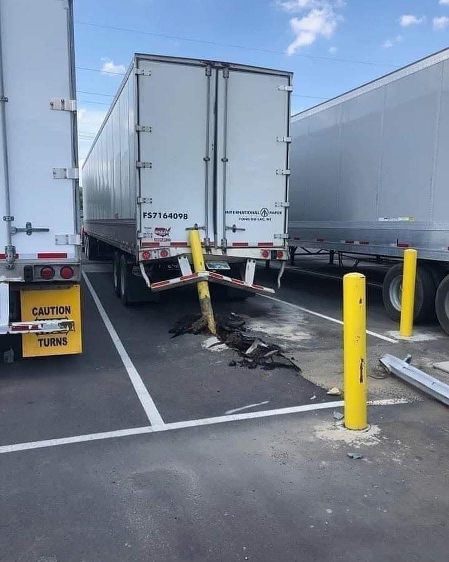 Nákladné auto zrazilo stĺpik na parkovisku, poškodenie viditeľné na asfaltovom povrchu.