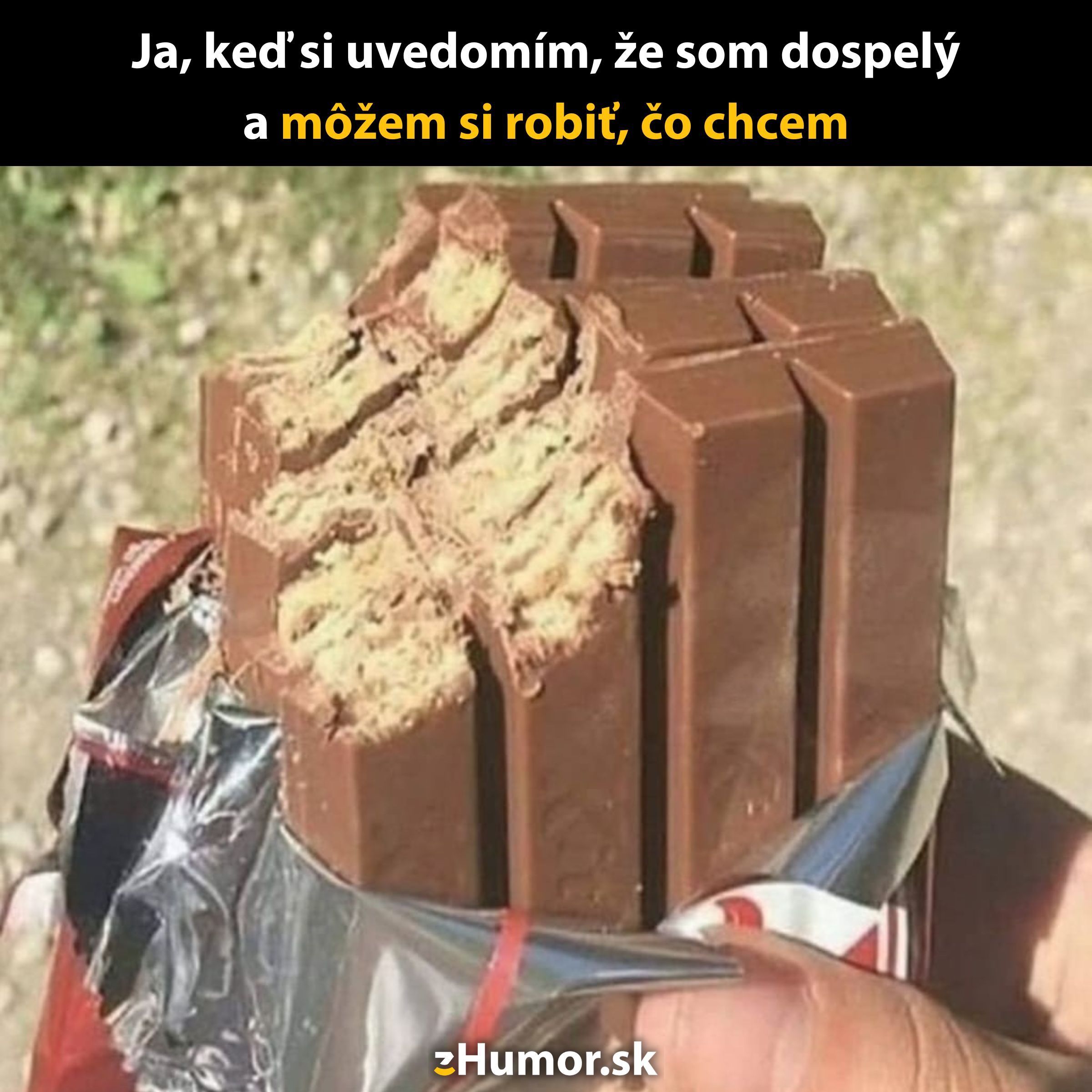 Osoba drží čokoládovú tyčinku s pokrčenými časťami, výstižný moment humoru z dospelosti.